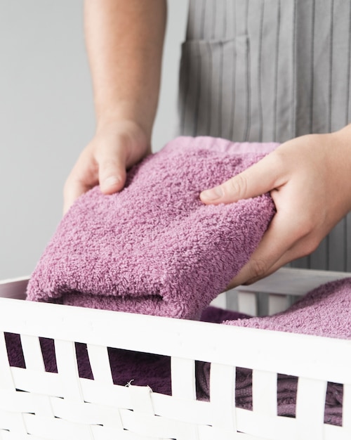 Close-uppersoon die handdoeken plaatsen in mand