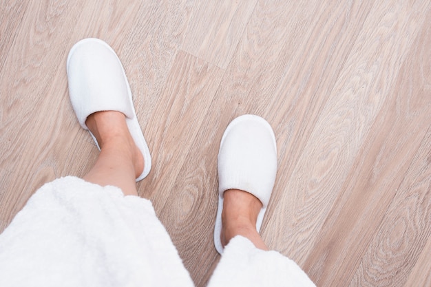 Close-uppersoon met witte schoenen op houten vloer