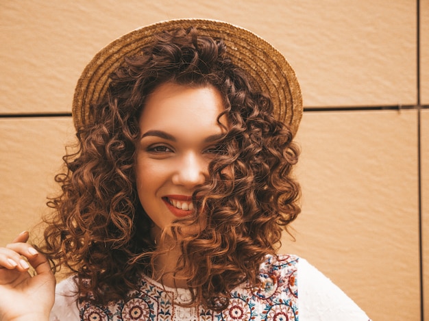 Gratis foto close-upportret van mooi het glimlachen model met het kapsel van afrokrullen gekleed in de zomer hipster witte kleding.