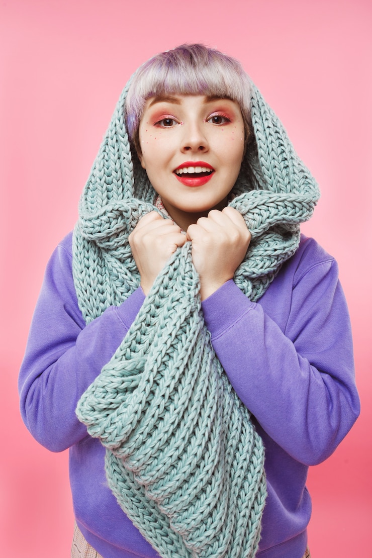 Gratis Foto close-upportret van mooi popachtig meisje met kort licht violet haar dat lila sweater draagt en grijze gebreide halswarmer over roze muur