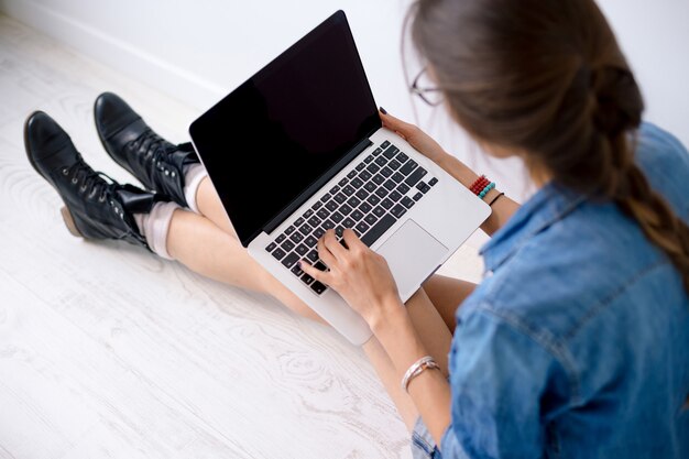 Close-upportret van vrouwenhanden die aan haar laptop toetsenbord werken