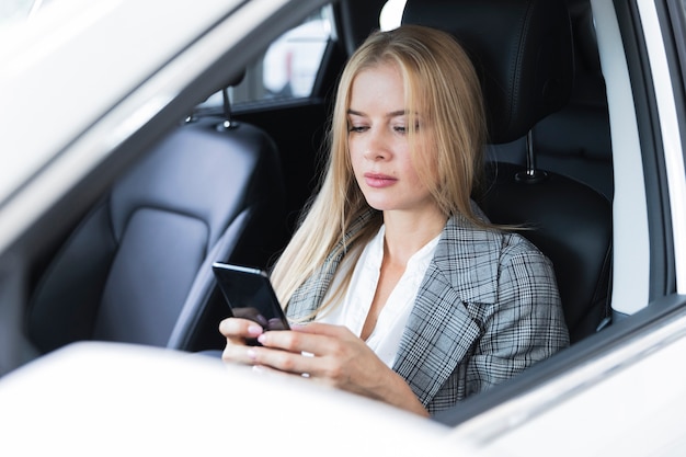 Close-upschot met een blondevrouw die telefoon bekijken