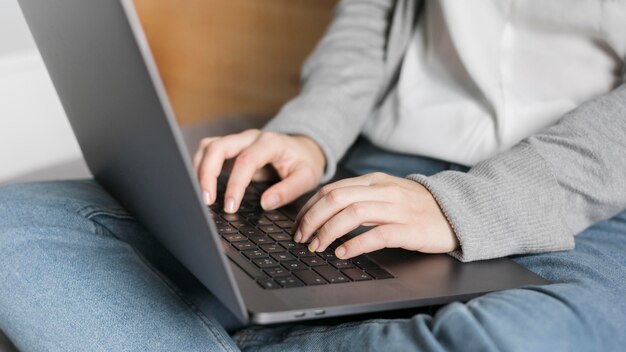 Close-upvrouw die aan laptop in bed werken