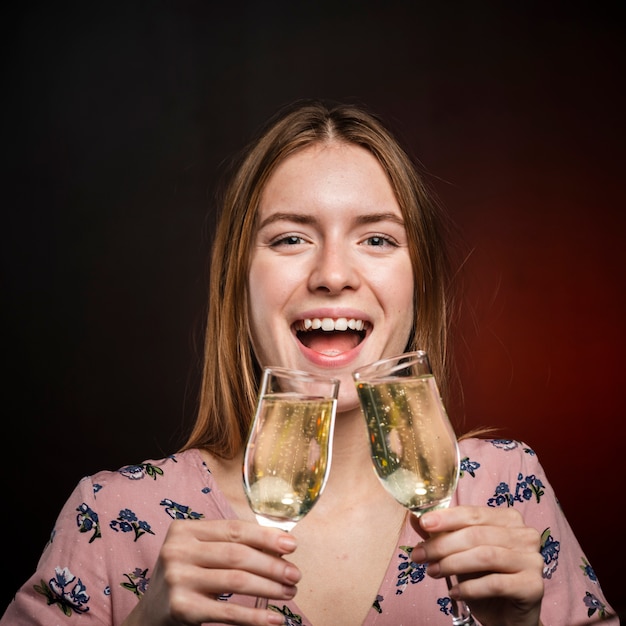 Gratis foto close-upvrouw die champagne van twee glazen proberen te drinken