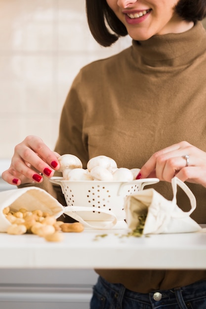 Close-upvrouw die eigengemaakte paddestoelen voorbereiden