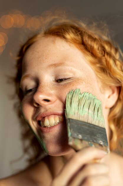 Close-upvrouw die haar gezicht schilderen