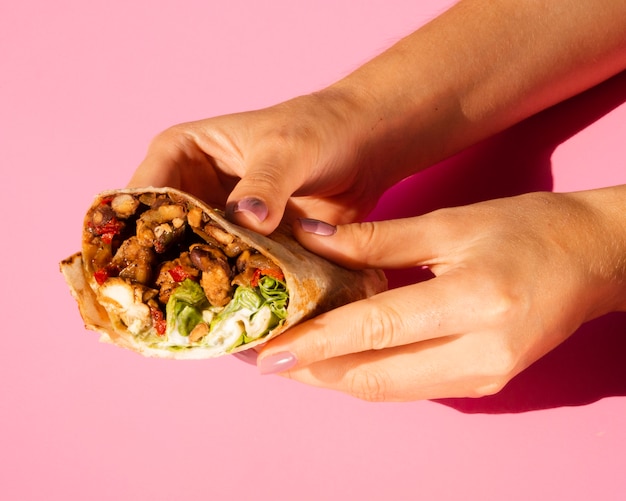 Gratis foto close-upvrouw die heerlijke burrito houden