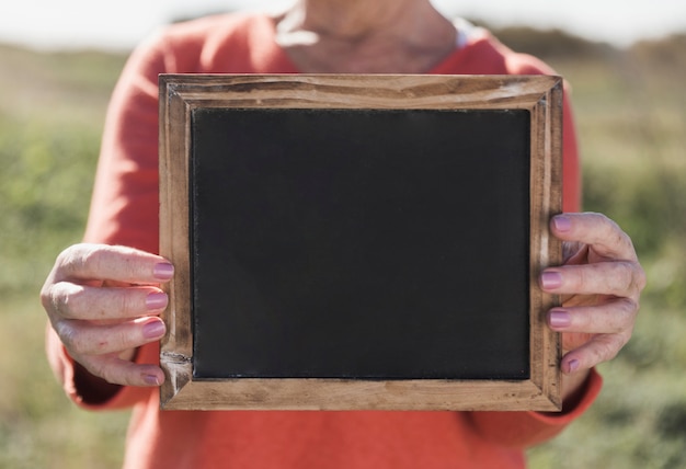 Gratis foto close-upvrouw die houten kader houden