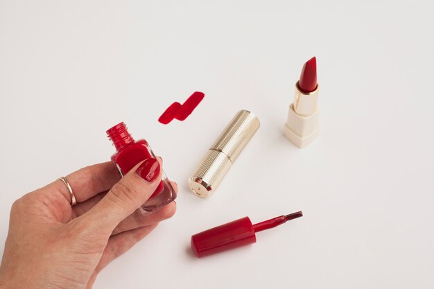 Close-upvrouw die rood nagellak houden