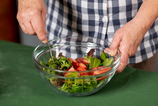 Gratis foto close-upvrouw die salade mengen