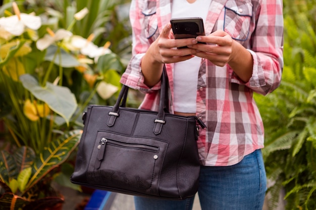 Close-upvrouw die telefoon in serre bekijken