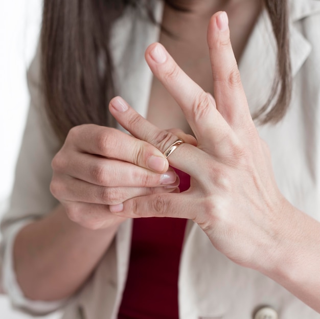 Close-upvrouw die trouwring vinger verwijderen