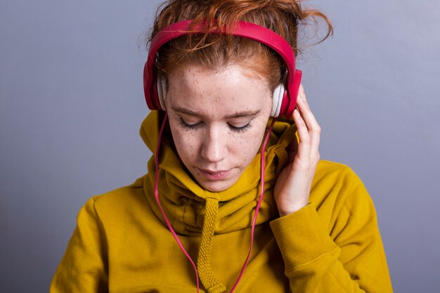 Close-upvrouw met gele hoodie en hoofdtelefoons