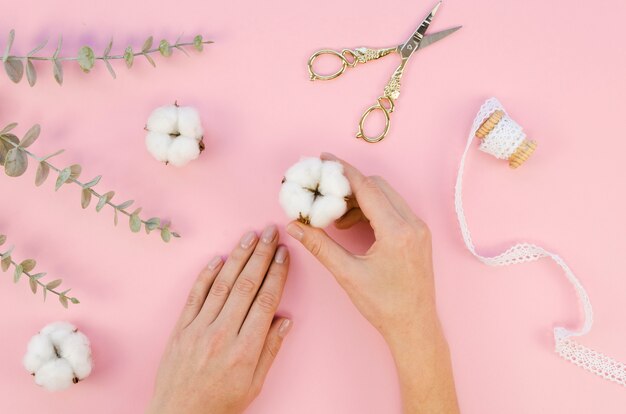 Close-upvrouw met katoenen bloemen en bladeren