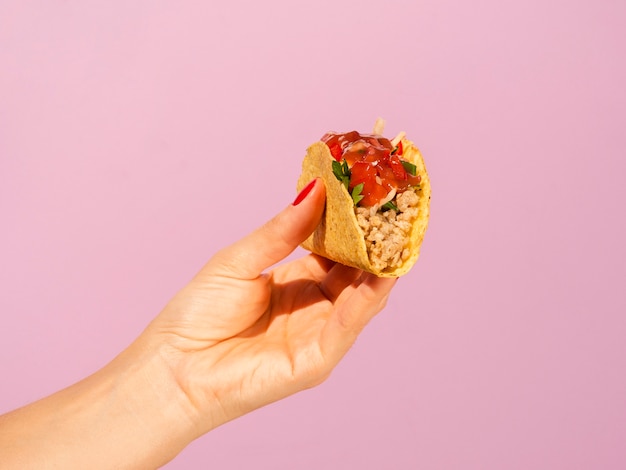 Close-upvrouw met taco en roze achtergrond