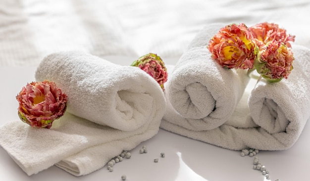 Closeup witte badstof badhanddoeken en bloemen