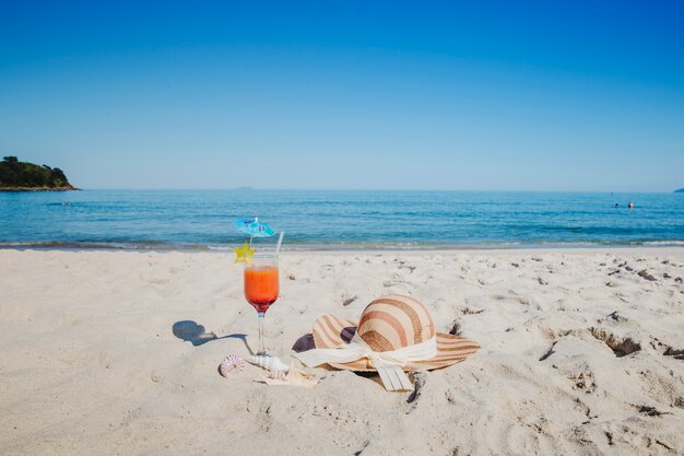Cocktail en hoed op het strand