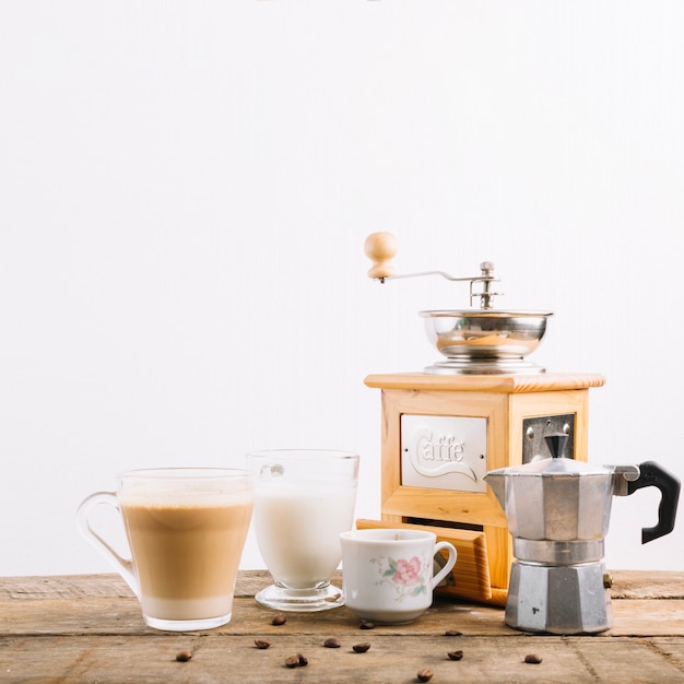 Coffemolen dichtbij koppen en pot