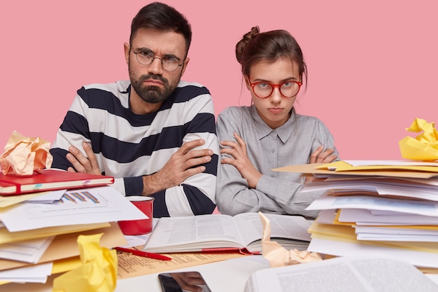 Collega's die aan bureau met documenten zitten