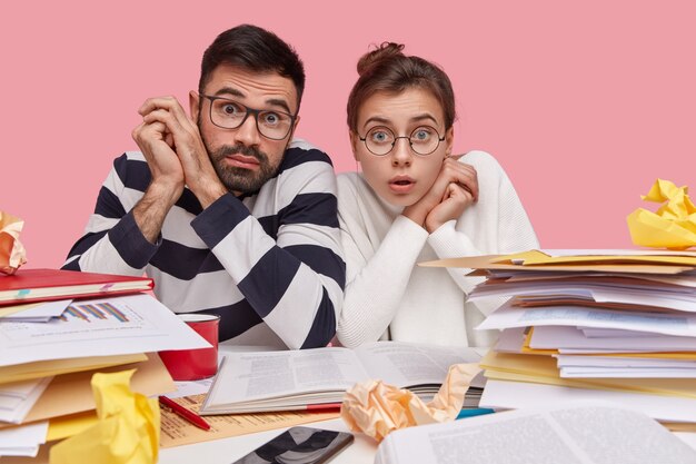 Collega's die aan bureau met documenten zitten