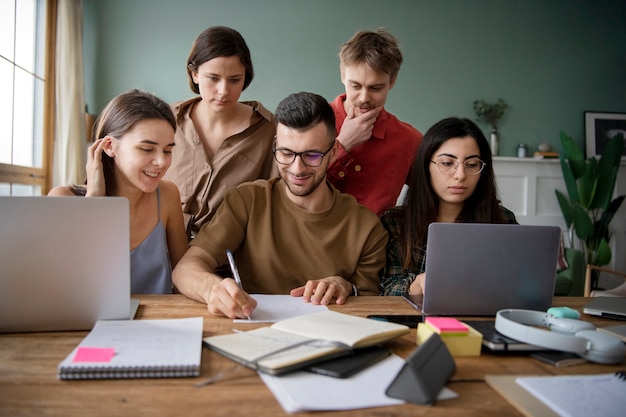 Collega's die laptops en notebooks gebruiken om te leren tijdens een studiesessie