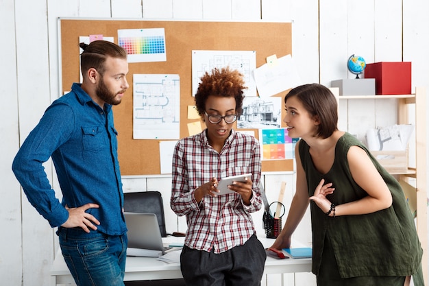 Collega's glimlachen, spreken en bespreken nieuwe ideeën op kantoor