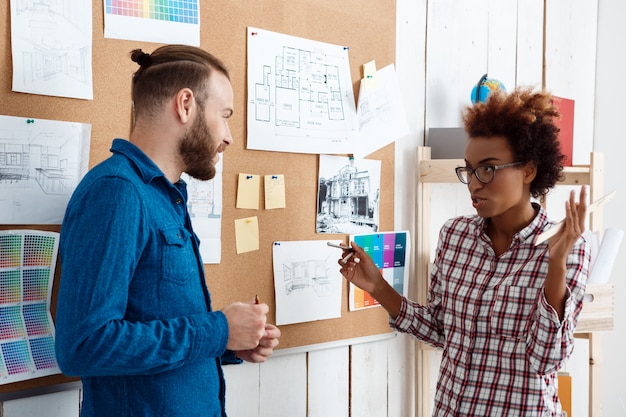 Collega's glimlachen, spreken en bespreken nieuwe ideeën