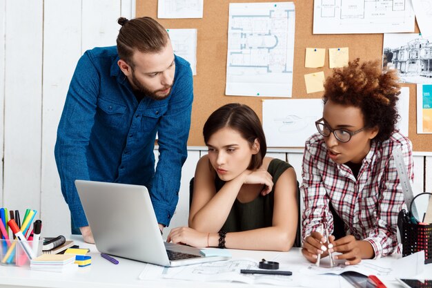 Collega's glimlachen, spreken, tekeningen bespreken, nieuwe ideeën op kantoor