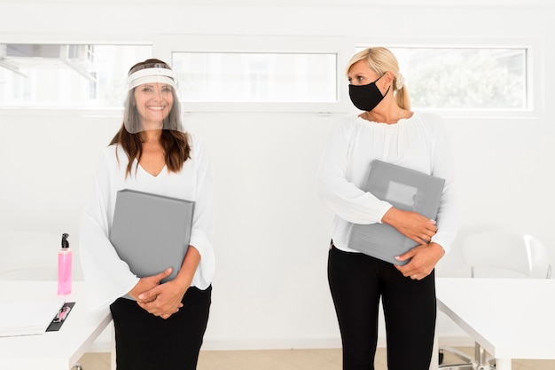 Collega's houden sociale afstand en dragen gezichtsbescherming