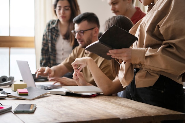 Collega's lezen met behulp van een laptop tijdens studiesessie