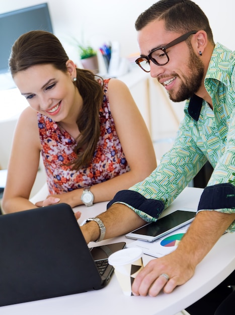 Collega's met behulp van laptop in het kantoor