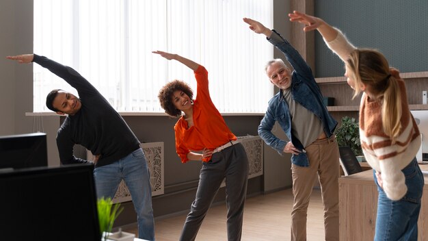 Collega's op kantoor die zich uitstrekken tijdens een werkdag