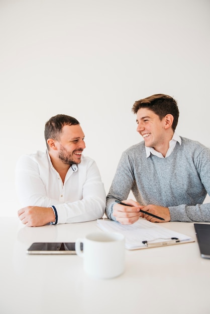 Gratis foto collega's op kantoor zitten aan tafel brainstormen