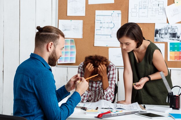 Collega's ruziën, tekeningen bespreken, nieuwe ideeën op kantoor