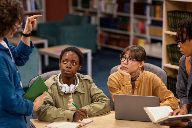 Collega's studeren samen in de universiteitsbibliotheek