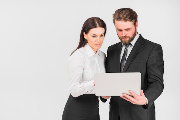 Collega&#39;svrouw en man die laptop bekijken