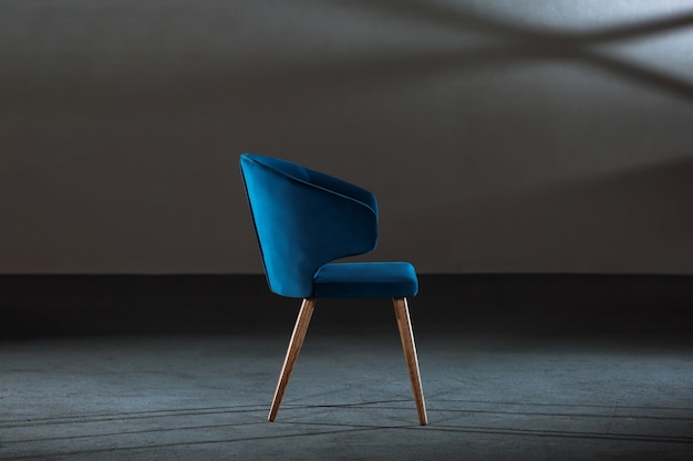 Comfortabele blauwe fauteuil in een kamer met grijze muren