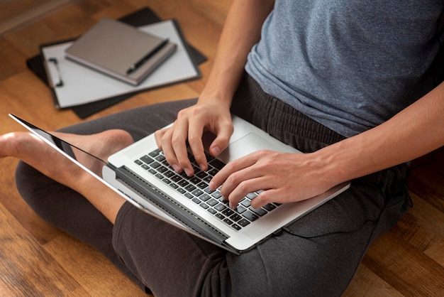 Comfortabele man met laptop thuis in quarantaine om te werken