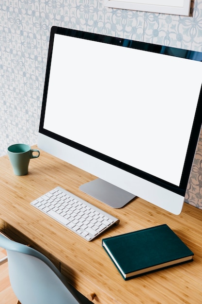 Computer, toetsenbord en dagboek op houten bureau