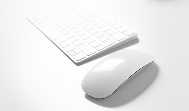 Computertoetsenbord en muis bovenop witte desktop