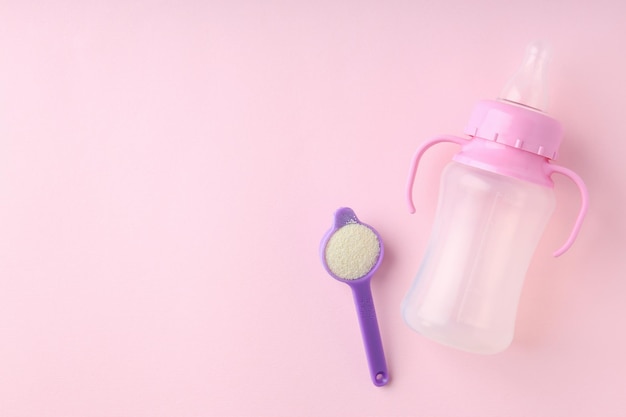 Concept van babyvoeding met â€owdered melk op roze achtergrond