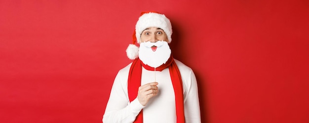 Concept van kerst wintervakantie en viering portret van grappige man in kerstmuts met beer...