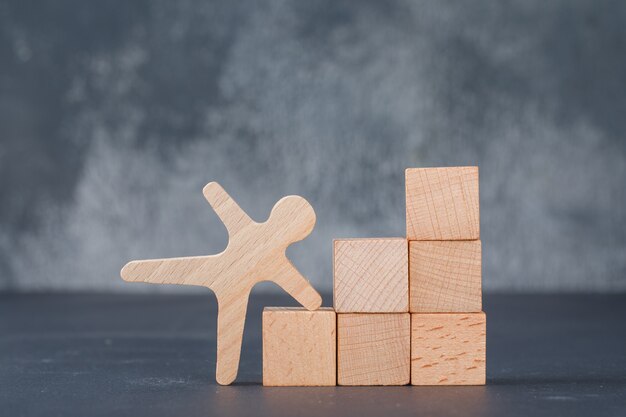 Conceptueel bedrijf met houten blokken zoals trappen met houten menselijke figuur.