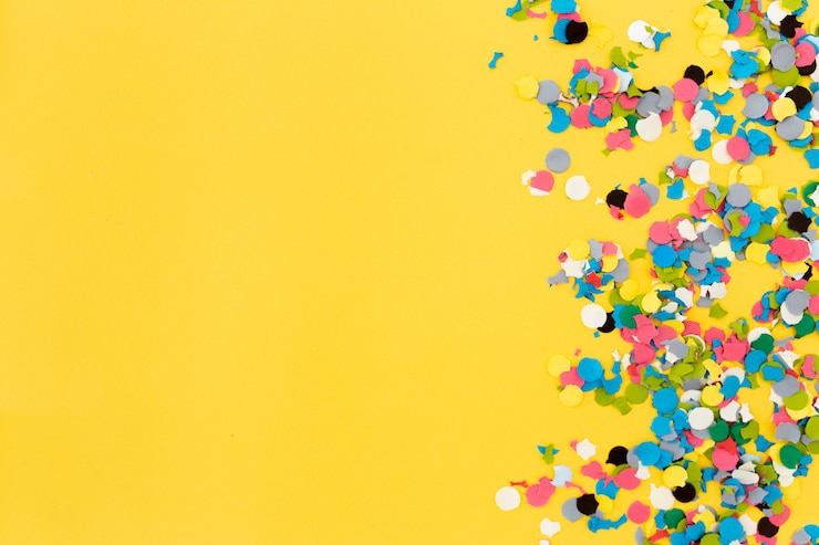 Gratis Foto confetti op gele achtergrond