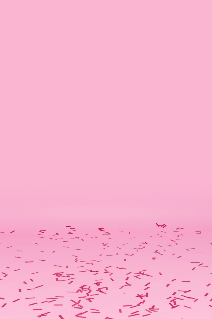 Gratis Foto confetti verspreid over roze achtergrond