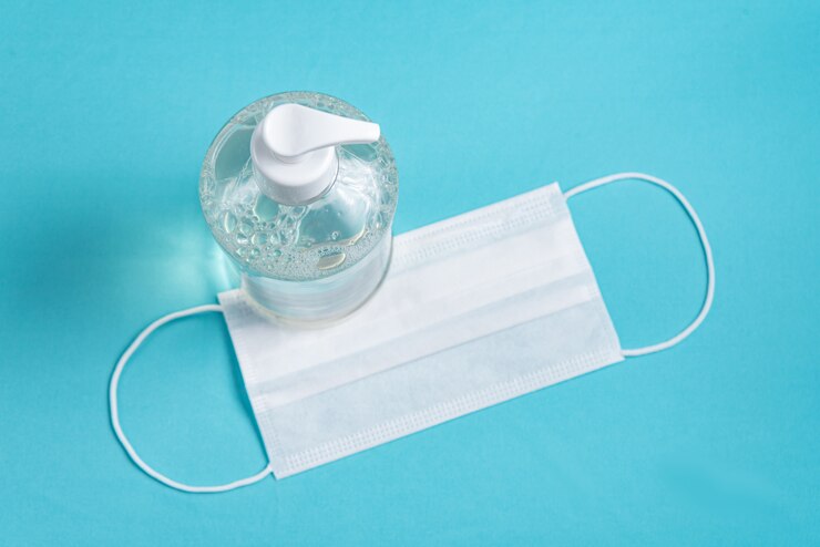 Gratis Foto container met alcoholgel en chirurgisch masker