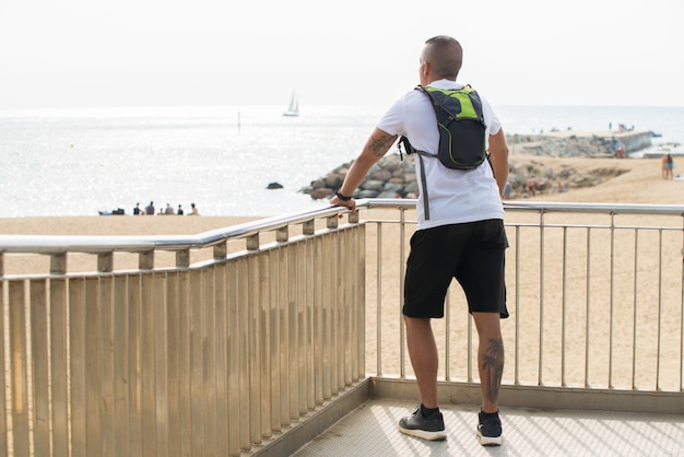 Contemplatieve sportman die op het strand rust