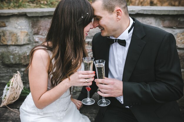 Content newlyweds poseren met wijnglazen