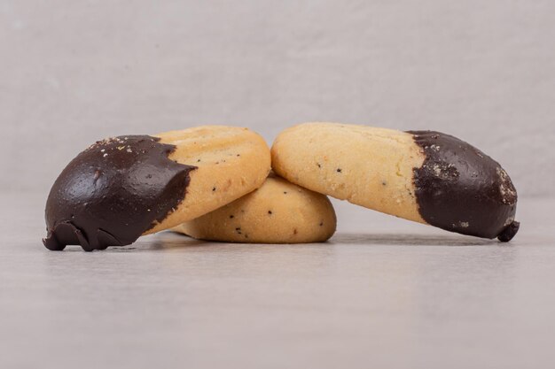 Cookies versierd met chocoladesaus op witte ondergrond.