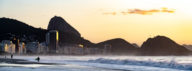 Copacabanastrand in Rio de Janeiro met de Suikerbroodberg bij zonsondergang